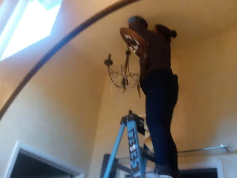 Electrician installing a chandelier in a Shiloh residence